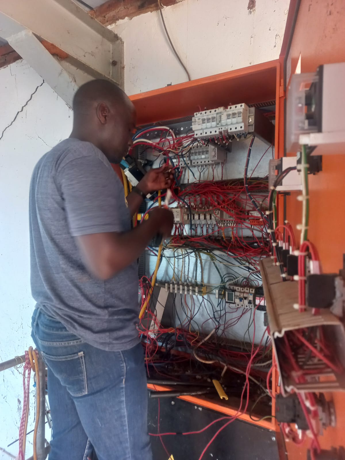 Technician wiring a large electrical distribution board