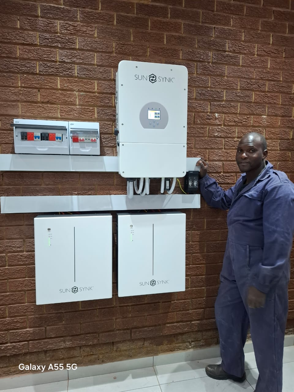 Completed solar inverter and battery setup with technician