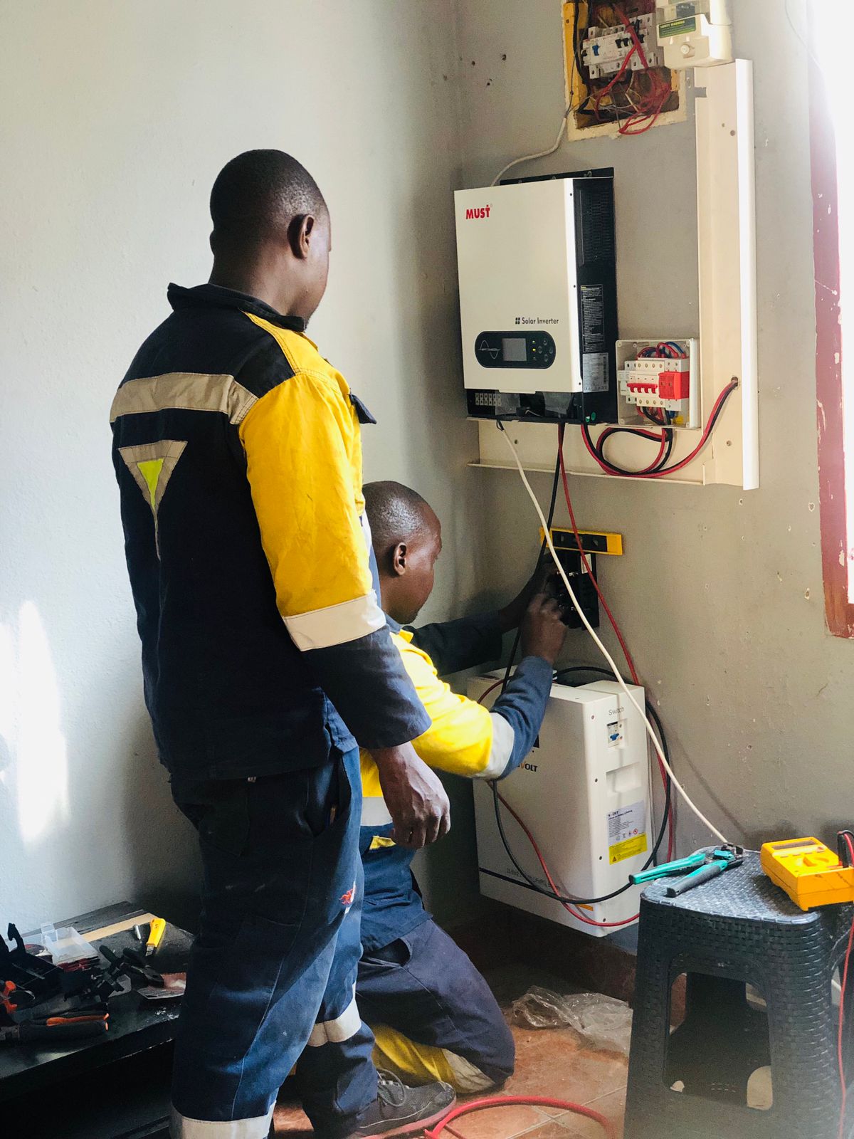 Technician working beside inverter and battery backup equipment